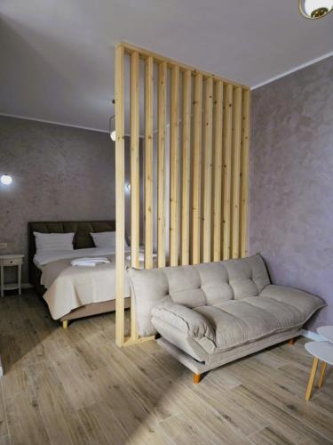 a living room with a couch and a bed at N&D Arinis Studio in Gura Humorului