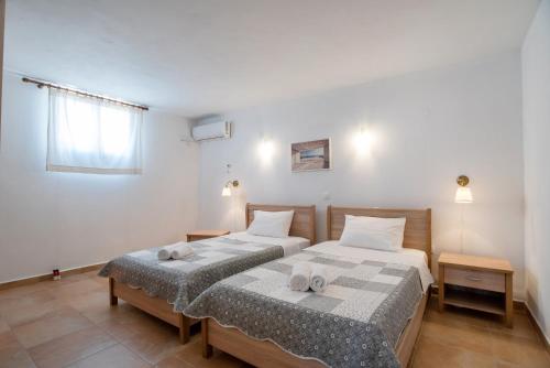 a bedroom with two beds with towels on them at Blue Xenia Villas Paros in Chrissi Akti