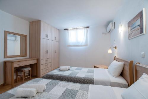 a small bedroom with two beds and a desk at Blue Xenia Villas Paros in Chrissi Akti