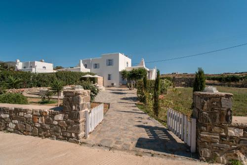 a stone path leading to a house with a fence at Blue Xenia Villas Paros in Chrissi Akti
