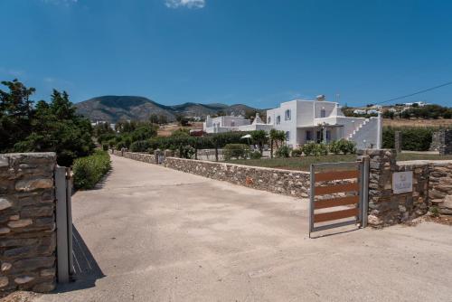 a walkway with a gate and a stone wall at Blue Xenia Villas Paros in Chrissi Akti