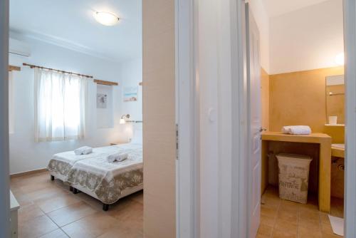 a small bedroom with a bed and a bathroom at Blue Xenia Villas Paros in Chrissi Akti