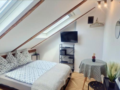 - une chambre mansardée avec un lit et une table dans l'établissement Pokoje gościnne u Brody, à Międzybrodzie Żywieckie