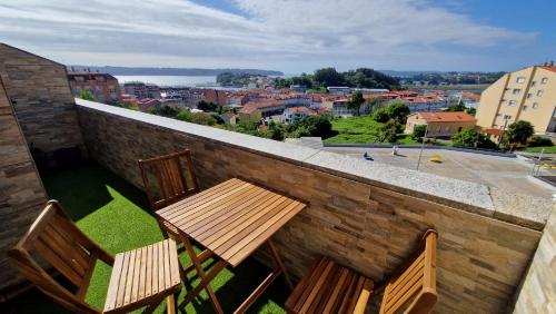 two chairs and a table on a balcony with a view at Apartamento CORAZÓN DE MIÑO in Miño