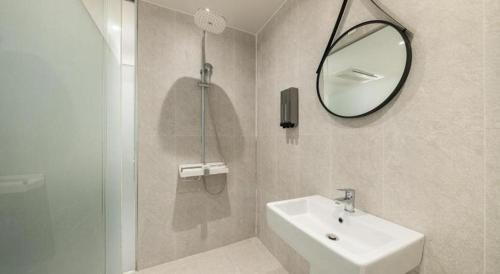 a bathroom with a sink and a mirror and a shower at Crossing Hotel in Seoul