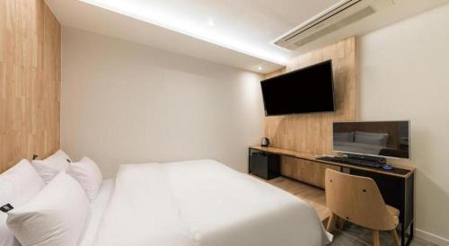 a hotel room with a bed and a flat screen tv at Crossing Hotel in Seoul