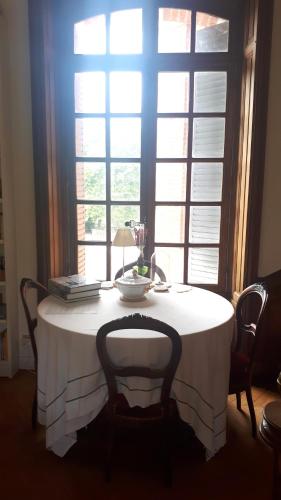 une table devant une fenêtre avec une nappe blanche dans l'établissement Appartement château classé, site remarquable, 1chbre, à Salbris