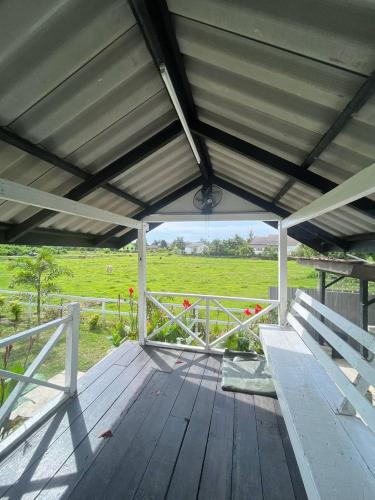 a wooden deck with a view of a field at Tok Abah Cottage in Kota Bharu