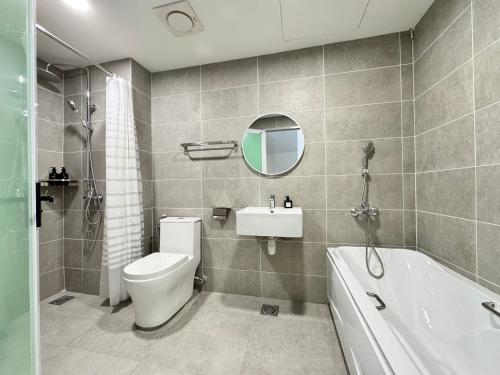 a bathroom with a toilet and a sink and a tub at ICC Ipoh Town Premium Suites By IWH Suites in Ipoh