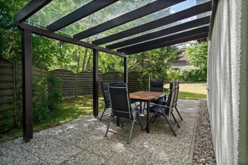 a patio with a wooden table and chairs at Ferienhaus Zander im Ferienpark Lenzer Höh in Funfseen