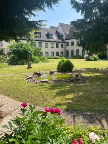 a building with a pond in the middle of a yard at Klosterhof Neustadt am Main in Neustadt am Main