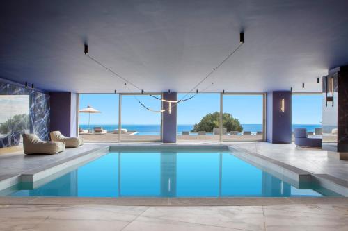 a swimming pool with a view of the ocean at Ajul Luxury Hotel & Spa Resort, a Registry Collection Hotel in Agia Paraskevi