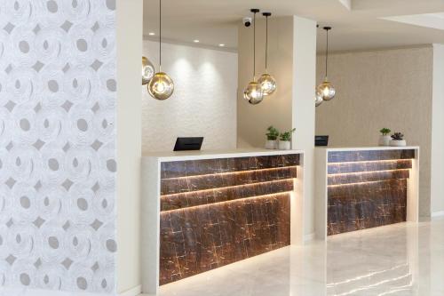 a lobby with a reception counter with lights at Ajul Luxury Hotel & Spa Resort, a Registry Collection Hotel in Agia Paraskevi
