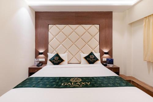 a bedroom with a bed with a green blanket on it at Galaxy Royal Suites in Bengaluru
