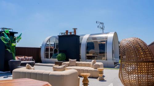 a patio with couches and tables and a building at Private Studio rooftop & Tour Eiffel View in Boulogne-Billancourt