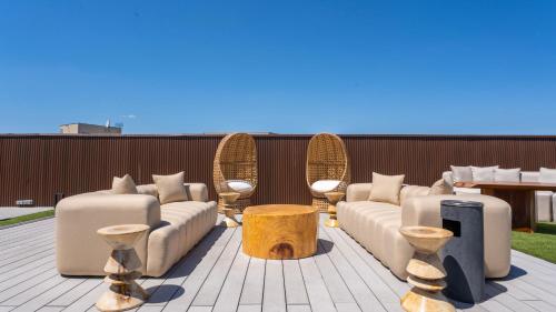 a patio with couches and tables and a table at Private Studio rooftop & Tour Eiffel View in Boulogne-Billancourt