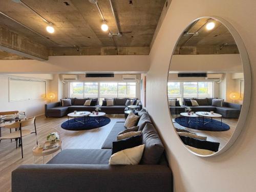 a living room with a couch and a round mirror at b hotel Dai3Himawari - Amazing Dome View 30 sec PeacePark, Up to 10 ppl in Hiroshima
