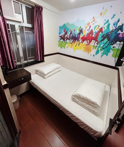 a bed in a room with a painting on the wall at National Inn Jordan Station in Hong Kong