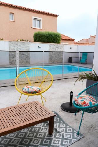 - deux chaises et un banc à côté de la piscine dans l'établissement Charmante villa à Saint Laurent de la Salanque, à Saint-Laurent-de-la-Salanque