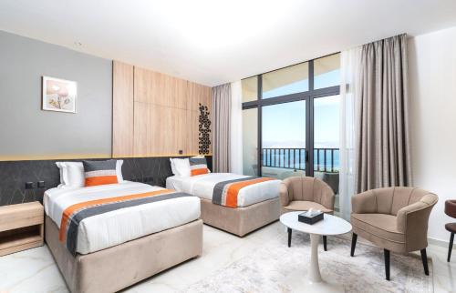 a hotel room with two beds and a balcony at Diamond Palm Hotel & Resort in Al Burj