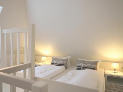 a bedroom with two bunk beds and two lamps at Skellinghörn 24, W5, DG in Morsum
