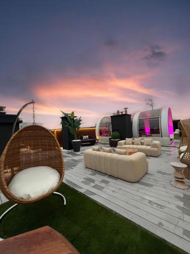 a patio with couches and chairs on a roof at Private Studio rooftop & Tour Eiffel View in Boulogne-Billancourt