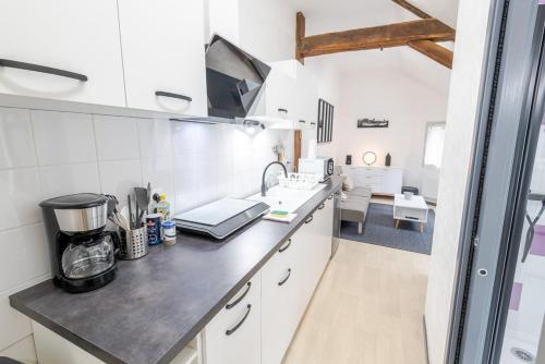 - une cuisine avec des murs blancs et un comptoir dans l'établissement Au coeur de Newton, à Amboise