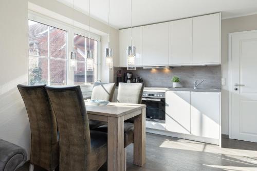 a kitchen with a table and chairs in a kitchen at Bellevue 02 in Laboe