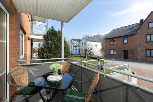 a patio with a table and chairs on a balcony at Bellevue 02 in Laboe
