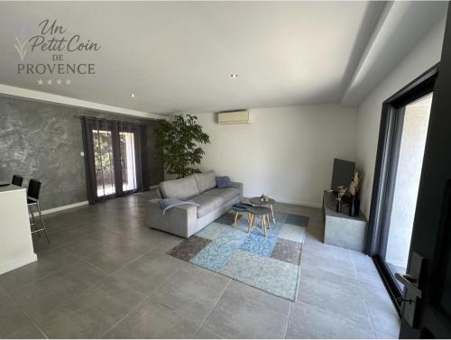 a living room with a couch and a table at Un Petit Coin de Provence - Istres - Maison Contemporaine Avec Piscine Privée Chauffée, Entre Plages Et Provence, Borne 11 kW in Istres