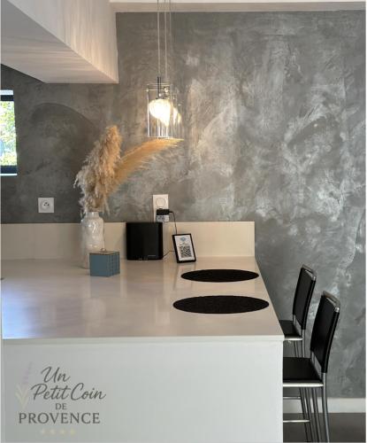 a kitchen with a counter with chairs in a room at Un Petit Coin de Provence - Istres - Maison Contemporaine Avec Piscine Privée Chauffée, Entre Plages Et Provence, Borne 11 kW in Istres