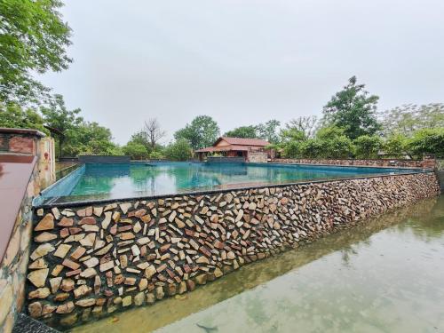 a swimming pool with a rock wall and water at Haveli Anirudh - Royalty Redefined in Jaipur