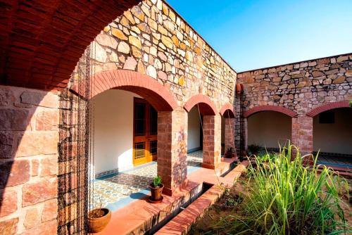 a brick building with arches and plants on it at Haveli Anirudh - Royalty Redefined in Jaipur