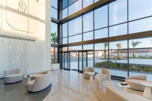 a lobby with white chairs and large windows at Diamond Palm Hotel & Resort in Al Burj