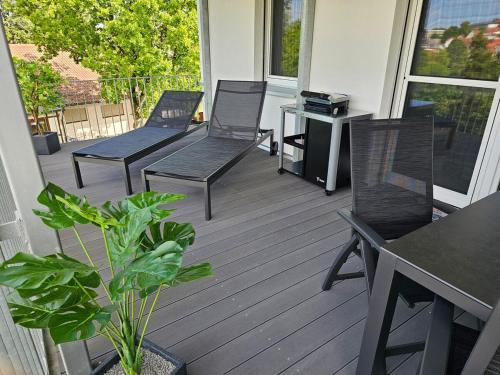 a porch with three chairs and a table and a desk at Ferienwohnung Stadtblick 13 in Pfullendorf