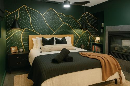 a bedroom with a large bed with a leafy wall at NEW Hot tub, Fireplace, Swing, Modern Cabin in Eureka Springs