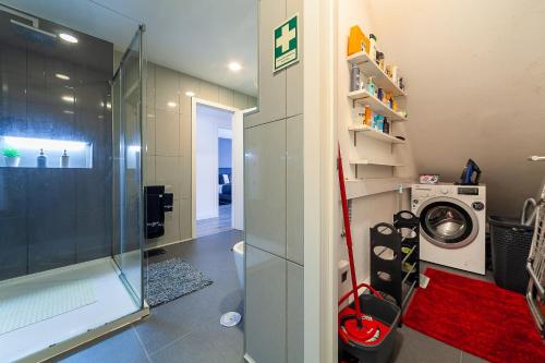 y baño con ducha y lavadora. en Lucky House (A L), en Praia de Esmoriz