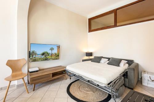 une chambre avec un lit et une chaise dedans dans l'établissement Vieille ville vue mer, à deux pas de la plage!, à Menton