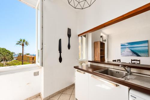 une cuisine avec un évier et une fenêtre dans l'établissement Vieille ville vue mer, à deux pas de la plage!, à Menton