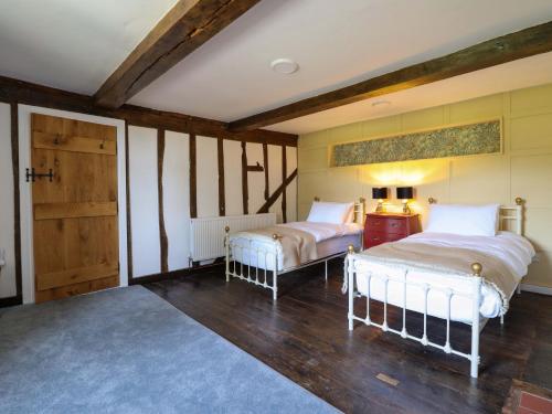 a bedroom with two beds and a door at Upper Dolarddyn in Welshpool