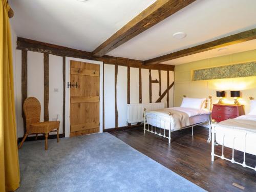 a bedroom with two beds and a table and a chair at Upper Dolarddyn in Welshpool