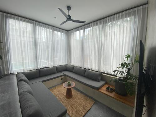a living room with a couch and a ceiling fan at Casa Malayka in Uluwatu