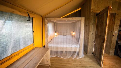 une chambre avec un lit avec moustiquaire dans l'établissement Lodge Holidays - Glamping Fouesnant, à Fouesnant