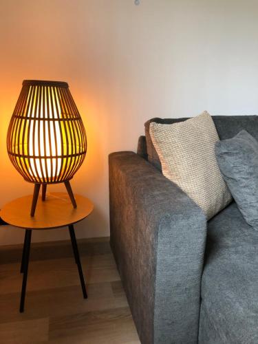una lámpara en una mesa junto a un sofá en Periplo home, en Camelle