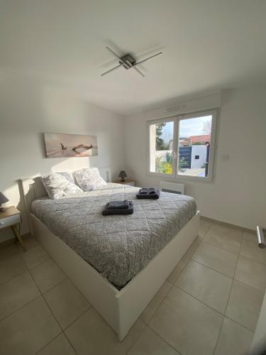 une chambre avec un lit avec un ventilateur de plafond dans l'établissement Villa contemporaine à 2 pas de la mer avec piscine privée, à Sainte-Marie-la-Mer