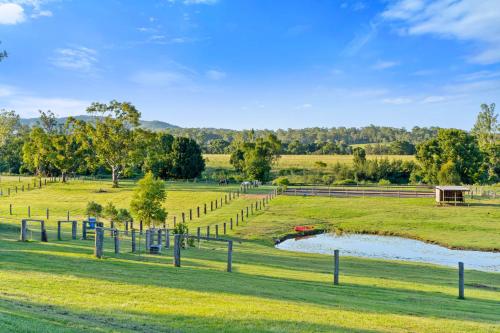 a farm with a pond in a grass field at Riverbend Ranch Tamborine in Tamborine