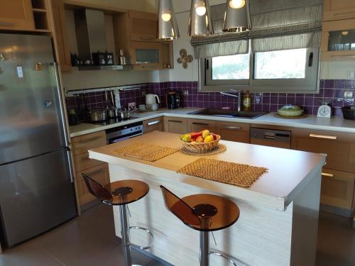 a kitchen with a table with a bowl of fruit on it at Villa Polyxeni 5 Bedrooms and Private Pool in Politiká