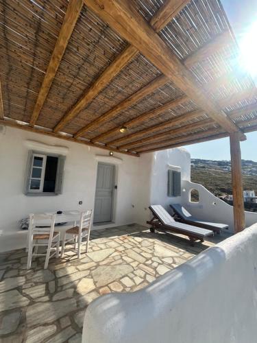 a patio with chairs and a table and a boat at Blue and White Mykonos ap2 in Mikonos