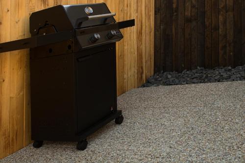 a black stove sitting next to a wooden fence at Wooden SPA in Hradec Králové