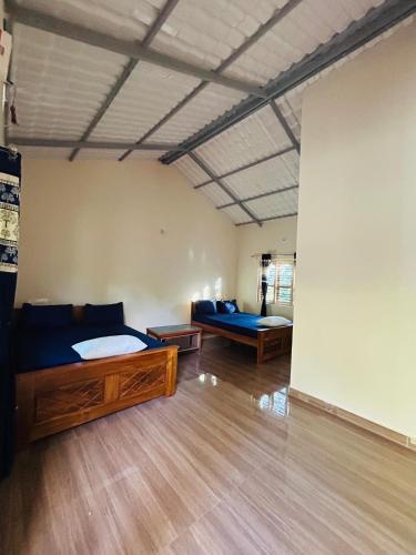 a room with two beds and a couch in it at Aqueduct Retreat in Kushālnagar